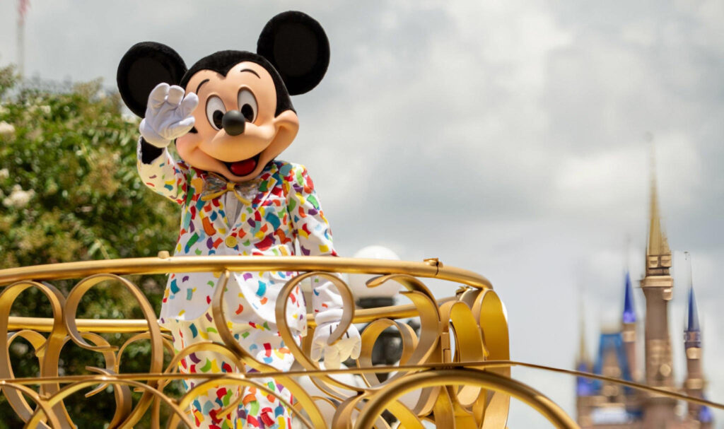 Mickey mouse in a carriage with a castle in the background.