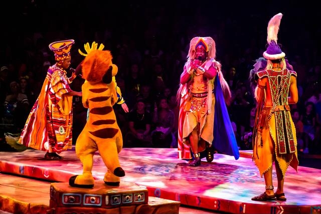 A vibrant ensemble of performers in elaborate costumes mesmerizing the audience in a thrilling stage production known as the Festival of the Lion King.