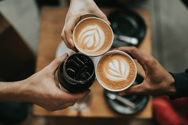 A group of people holding cups of coffee.