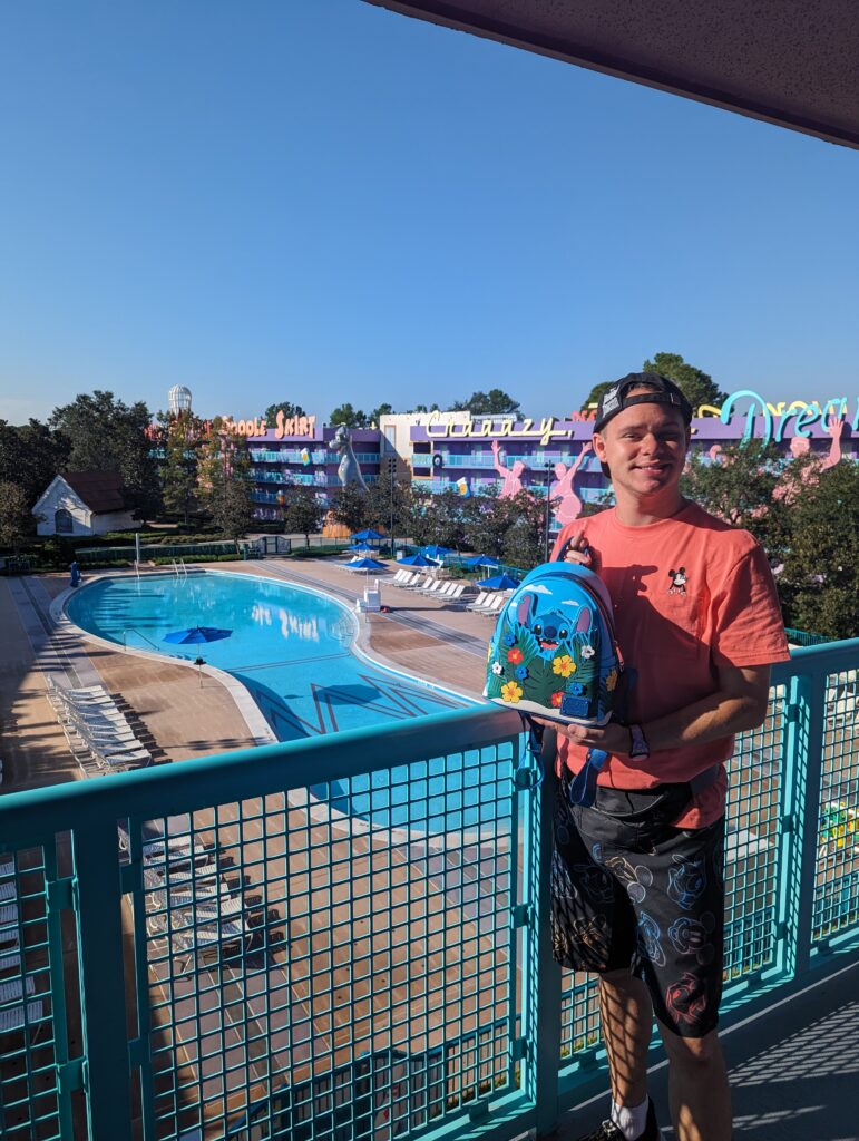 Disney World traveler in front of Pop Century Resort pool with Stitch Loungefly