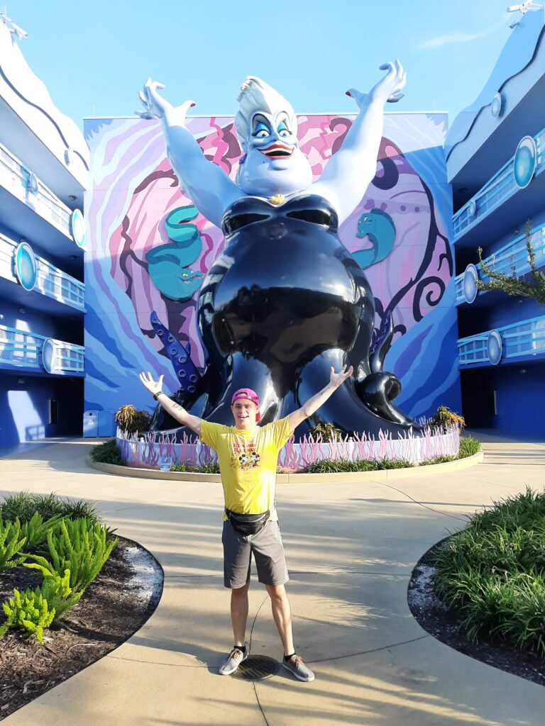 a man standing in front of a large Ursula from The Little Mermaid statue at Art of Animation.