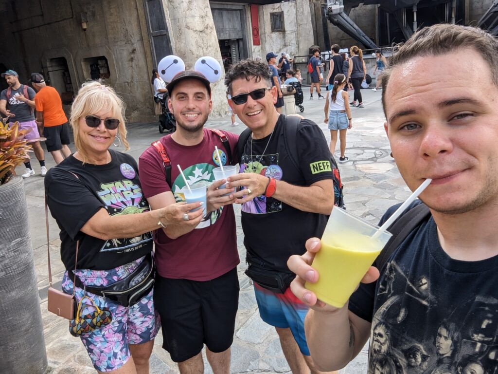 A family of four drinking the blue milk and the green milk in Galaxy's Edge in Hollywood Studios at Hollywood Studios.