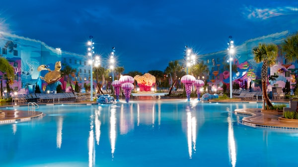 a pool with lights and a building